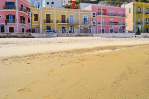 una playa de arena con edificios coloridos en el fondo en Maridea - In Riva al Mare, en Ponza