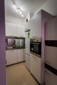 a kitchen with white appliances and purple walls at Apartment Studio BOSSANOVA in Bydgoszcz