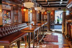 une rangée de tables et de chaises dans un restaurant dans l'établissement Hotel Bishops Arms Strängnäs, à Strängnäs