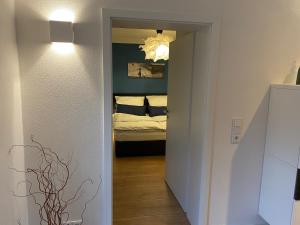 a hallway leading to a bedroom with a bed at Schwalm-Apartment Treysa in Schwalmstadt