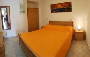 a bedroom with a bed with an orange blanket at Maridea - Fragolino in Ponza +3 photos