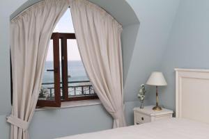 a bedroom with a window with a view of the ocean at Villa Allegra in Kavarna