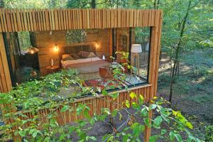Loire Valley Lodges - Hotel في Esvres: منزل في الغابة مطل على غرفة نوم