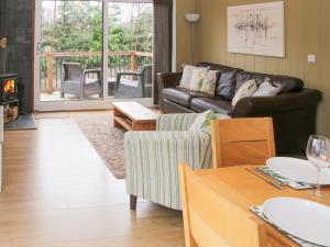 a living room with a couch and a table at Willow River Lodge in Craven Arms
