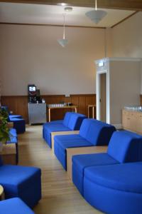a waiting room with blue couches and a tv at Hinsley Hall in Leeds