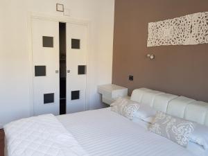 a white bed with white pillows in a bedroom at B&B Stefani in Salerno