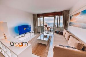 a living room with a couch and a tv at CASA CHIARINA breathtaking sea view in Ravello