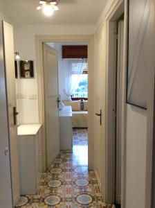 um corredor que leva a uma casa de banho com lavatório em La Casa di Renata by PortofinoVacanze em Rapallo
