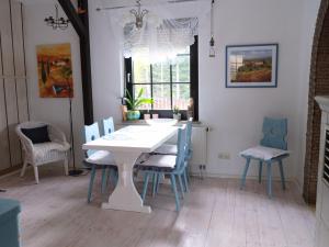 ein Esszimmer mit einem weißen Tisch und Stühlen in der Unterkunft Ferienwohnung am Walde in Rauda