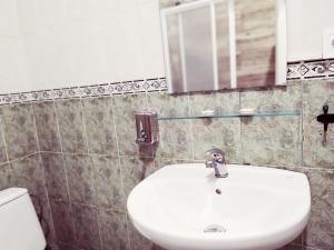 
a white sink sitting under a mirror in a bathroom at Spanish Galleon Lodge in Cádiz
