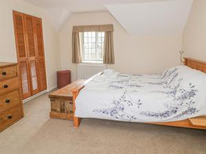 a bedroom with a large bed and a wooden dresser at Spring Cottage in Banbury