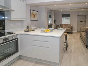 a kitchen with a white counter top and a living room at 5 Coley Lane in Stafford