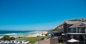 a view of a beach with cars parked in front of a building at Brenton Haven Beachfront Resort in Knysna