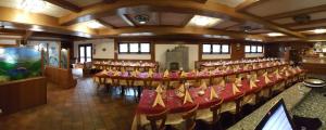 a large room with a bunch of tables and chairs at Canè in fiore in Baselga di Pinè