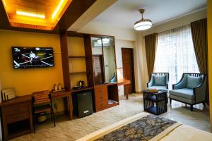 a living room with a television on a wall at Shinepukur Suites in Dhaka