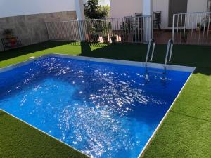 basen z błękitną wodą na dziedzińcu w obiekcie Casas Juani- chalet con piscina w mieście Conil de la Frontera