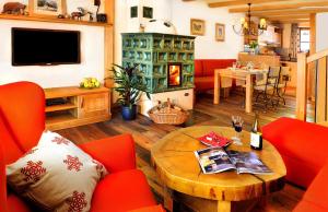 a living room with red chairs and a table at Panoramic Mountain Residence in Starý Smokovec