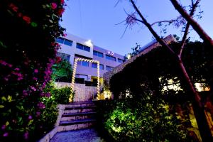 a set of stairs in front of a building with flowers at VU'Z Hotel in Jbeil
