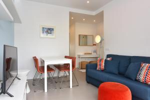 フィゲイラ・ダ・フォズにあるMaestro Apartment by Trip2Portugalのリビングルーム(青いソファ、テーブル付)