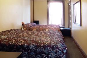 a bedroom with a bed with a floral bedspread at OYO Hotel Bradford Main St PA in Bradford