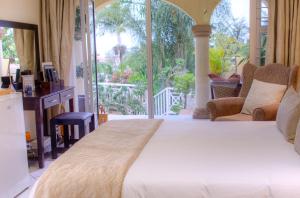 a bedroom with a large bed and a balcony at Anchor's Rest Guesthouse and Self Catering in Durban