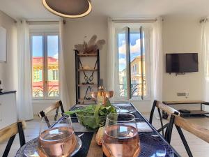 een eetkamer met een tafel met glazen erop bij Nestor&Jeeves - MASSENA DREAM - Hyper center - Close sea in Nice