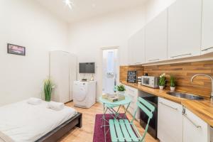 uma pequena cozinha com uma cama e um lavatório em Real Apartments Anker II em Budapeste