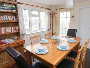 a dining room with a wooden table and chairs at The Old Bakehouse in Llantwit Major