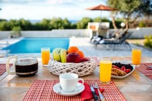 a table with a bowl of fruit and a basket of juice at Vasilis Villa in Phanaes