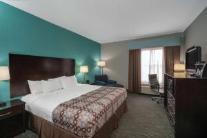 a hotel room with a bed and a television at La Quinta by Wyndham Knoxville East in Knoxville