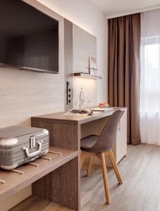 a kitchen with a desk with a suitcase at Hotel Newton Ludwigshafen in Ludwigshafen am Rhein