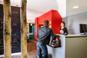 a man standing at a counter in front of a woman at hotelF1 Cholet R&eacute;nov&eacute; in Cholet