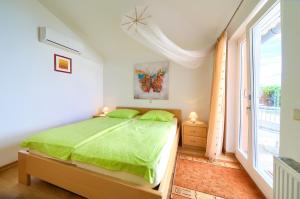 ein Schlafzimmer mit einem grünen Bett und einem Fenster in der Unterkunft Apartment Vjeko in Vantačići