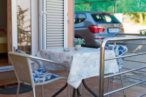 einen Tisch und Stühle auf einer Veranda in der Unterkunft Apartment Vjeko in Vantačići