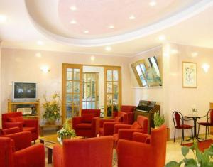 a waiting room with red chairs and a table at Hotel Vallechiara in Cesenatico