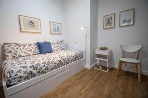1 dormitorio pequeño con 1 cama y 1 silla en Duplex Flamingo Cadiz, en Cádiz