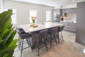 a kitchen with a large white island with stools at Host & Stay - Lemonade Arch in Whitby
