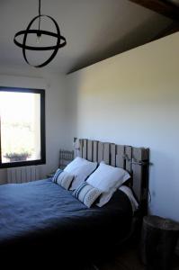 1 dormitorio con cama con almohadas y ventana en MAS CAMBEL, en Brouilla