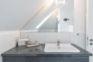 a bathroom with a sink and a toaster at Haus Passat - Ferienwohnungen in Ostseebad Nienhagen