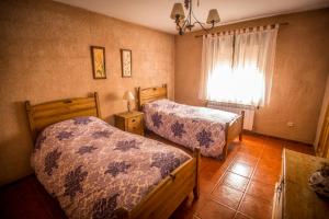 a bedroom with two beds and a window at Casa La Escondida in Duruelo