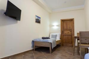 a bedroom with a bed and a tv on a wall at Penzion Růže in Benešov nad Ploučnicí