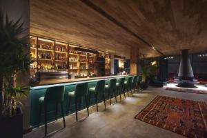 a bar with green chairs in a restaurant at Gudauri Lodge in Gudauri