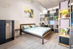 a bedroom with a bed in a room with shelves at Industrial Apartment ZERO in Bratislava