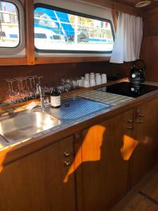 a kitchen with a sink and a counter with a window at Boot & Breakfast - slapen op het water in Enkhuizen +14 photos