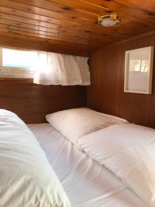 two beds in a bedroom with a wooden ceiling at Boot & Breakfast - slapen op het water in Enkhuizen