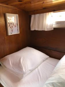 uma cama num quarto com uma janela e uma almofada branca em Boot & Breakfast - slapen op het water em Enkhuizen