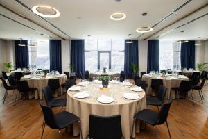 a conference room with tables and chairs and large windows at Gudauri Lodge in Gudauri