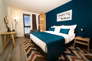 a hotel room with a large bed with blue walls at Gudauri Lodge in Gudauri