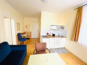 a living room with a blue couch and a kitchen at Apartment Barbara in Mariánské Lázně