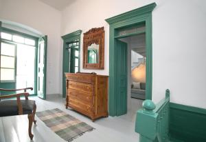 una camera da letto con cassettiera in legno e specchio di Scaleri Port Home a Calimno (Kalymnos)